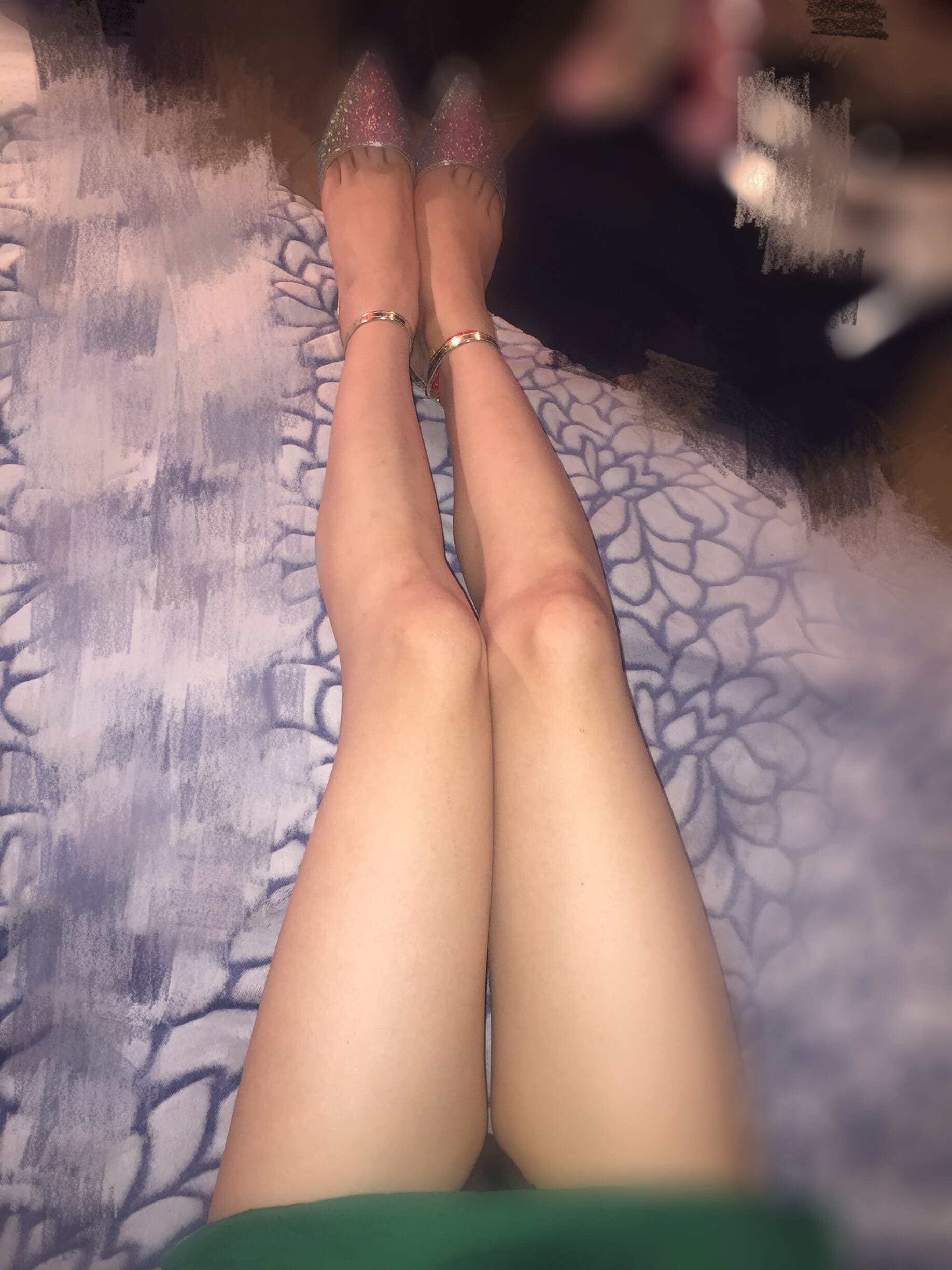 Black pantyhose-clad legs crossed on a chaise, toes just visible at the hem, hinting at a coy barefoot reveal.